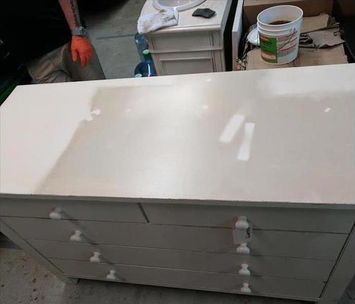 soot-covered white dresser, partially cleaned