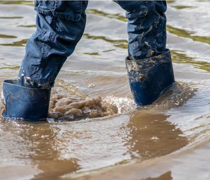 Person wearing boots walking through floodwater