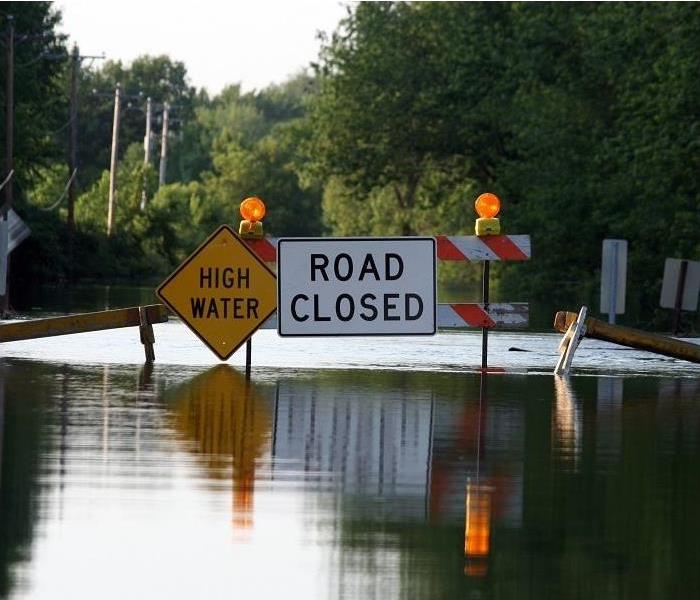 Floodwater on road; ‘high water, road closed’ signs